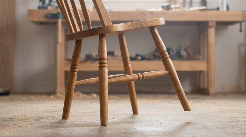Hands applying wood glue to a loose chair leg joint during repair